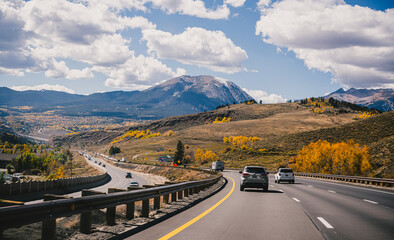 Driving down a highway in the fall through the Rocky Mountains - obrazy, fototapety, plakaty