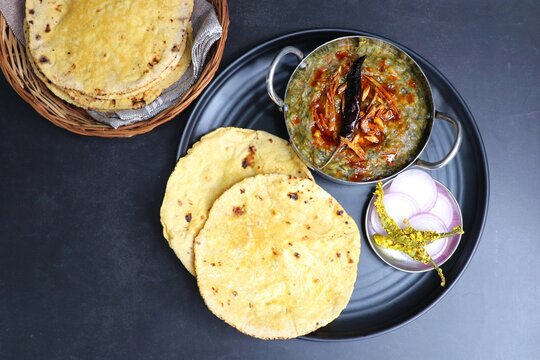Sarson ka saag and Makke di roti. mustard leaves curry. It's a popular Punjabi winter dish made using corn meal and mustard leaves. served with onions and green chili. with copy space.