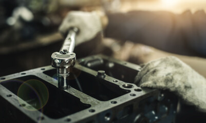 Auto mechanic working on car engine in mechanics garage. Repair service. Car care maintenance and servicing, Close-up hand technician auto mechanic using the wrench to repairing change spare.