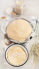 Raw dough pastry in a bowl on neutral background.
