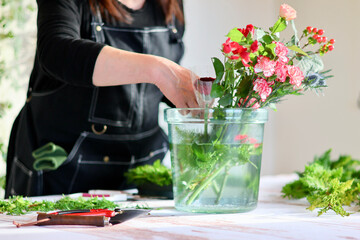 Obraz na płótnie Canvas 生花を使った華やかなフラワーアレンジメント　手作りの花のリース　女性フラワーデザイナー