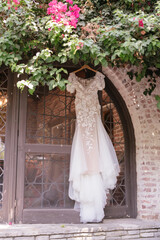 bridal dress hanging on the wall in the summer day