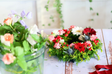 Fototapeta na wymiar 生花を使った華やかなフラワーアレンジメント　手作りの花のリース　女性フラワーデザイナー