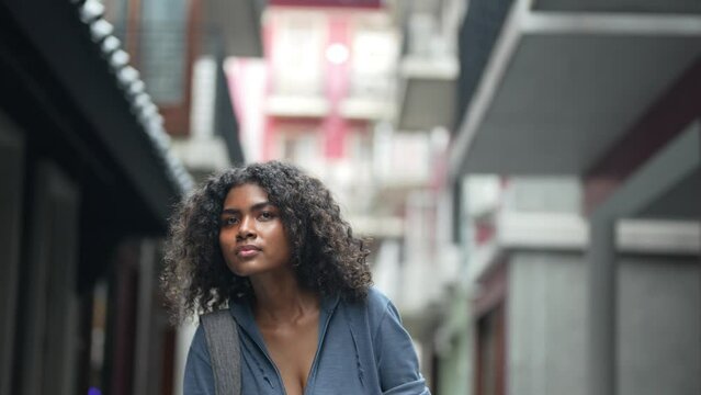 african business woman having lifr style at outdoor pedestrian space. woman in relaxing holding laptop. girl walking in relaxing and happy. she call and hand up to someone or friend.