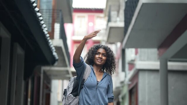 african business woman having lifr style at outdoor pedestrian space. woman in relaxing holding laptop. girl walking in relaxing and happy. she call and hand up to someone or friend.