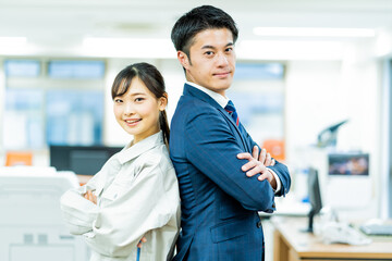 作業服を着た女性とスーツを着た日本人男性