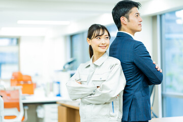 作業服を着た女性とスーツを着た日本人男性