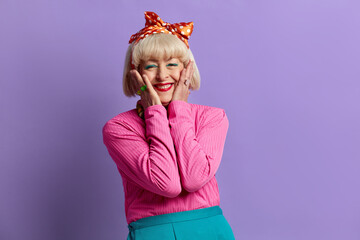Amazed Granny Feeling Surprised. Portrait Of Excited Senior Woman Touching Face And Looking Surprised By Crazy News. Indoor Studio Shot Isolated On Violet Background 