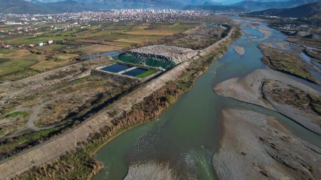 City dump garbage mountain of unsorted waste at landfill next to river, ecological problem in Elbasan Albania