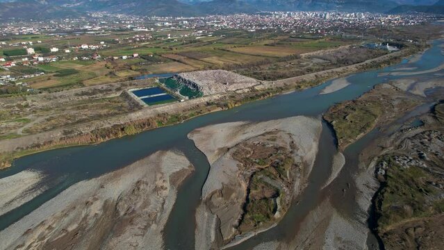 Ecological disaster on the banks of the river near the city of Elbasan in Albania from the waste landfill and sand mining enterprises