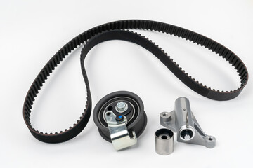 Timing belt and tension rollers of the gas distribution system of the automobile engine, the concept of car maintenance. New set of spare parts on a white background. View from above - obrazy, fototapety, plakaty