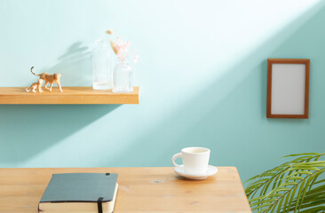 front view of wooden desk table with offie supplies and cyan background. copy space
