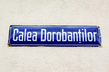 Beautiful vintage street sign showing Calea Dorobantilor (Dorobantilor Avenue) displayed on an street in the old city center of Bucharest, Romania, in a sunny day with clear blue sky