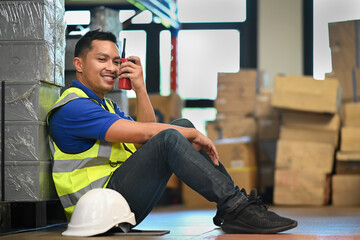Storehouse worker sitting in a retail warehouse and communicating with walkie talkie