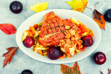 Pork shoulder baked with vegetables and plums.
