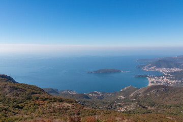 Panoramic aerial view on the coastline of Budva and Sveti Nikola Island seen from Goli Vrh, Adriatic Mediterranean Sea, Montenegro, Balkan, Europe. Luxury hotel resorts along Budvanian Riviera.