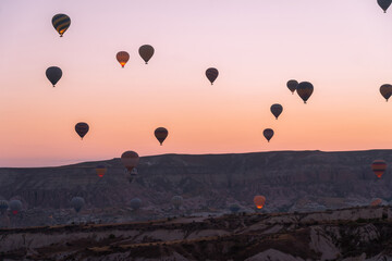 Balloons flying against the background of a beautiful sunrise in Cappadocia. A popular tourist destination for summer holidays