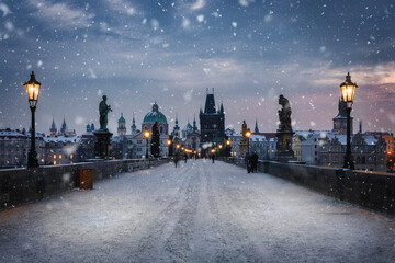 View over the snow covered Charles Bridge in Prague to the skyline of the old town during a cold winter morning, Czech Republic