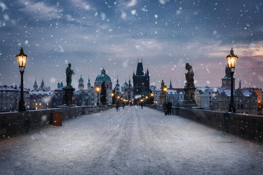View over the snow covered Charles Bridge in Prague to the skyline of the old town during a cold winter morning, Czech Republic - Powered by Adobe
