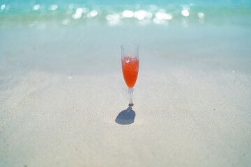 A cocktail beer alcohol drink glass on sea sand beach background. Sweet fruit food. People lifestyle. Summer season during travel holidays vacation trip