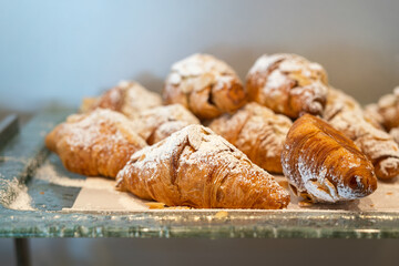 Group of baked croissant with sugar icing topping in the glass plate, serving in the breakfast buffet line. Food object photo.
