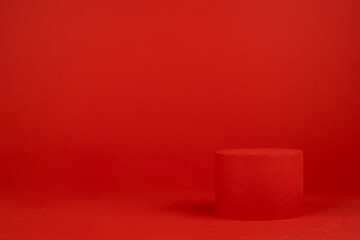 Red festive Christmas stage with one cylinder podium mockup on table for presentation cosmetic products, gifts, goods in simple modern minimalist style, copy space. Template for advertising, design.