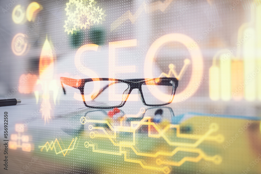 Poster SEO hologram with glasses on the table background. Concept of search engine optimization. Double exposure.
