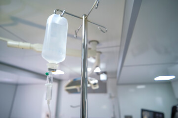 Intravenous or Iv fluids drip bottle hanging on a metal pole in hospital emergency room. Equipment...