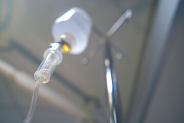 Intravenous or Iv fluids drip bottle hanging on a metal pole in hospital emergency room. Equipment and medical devices.