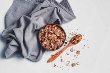 Homemade granola in a coconut bowl on a white background.