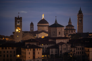 Naklejka premium Bergamo. One of the beautiful city in Italy. Landscape at the old town from the hill at evening. Amazing view of the towers, bell towers and main churches. Touristic destination. Best of Italy