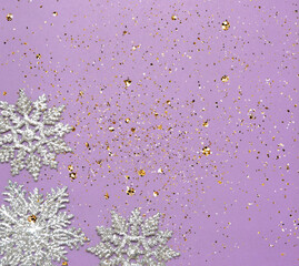 Obraz premium silver glittering snowflake ornaments on violet ground with sparkle and space for text christmas background