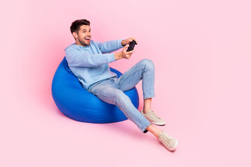 Photo of positive stylish man have relax rest home free time playing gta game empty space isolated on pink color background © deagreez