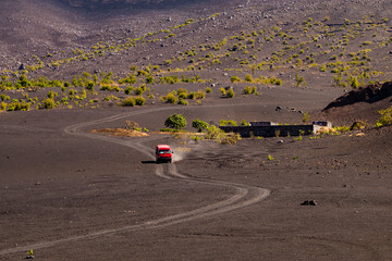 A minibus rides on the ash in the crater of the volcano Pico do Fogo, Cape Verde Islands