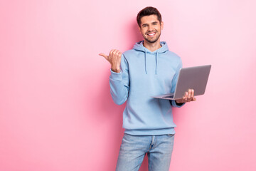 Photo of positive charming guy dressed blue sweatshirt typing modern gadget thumb empty space...