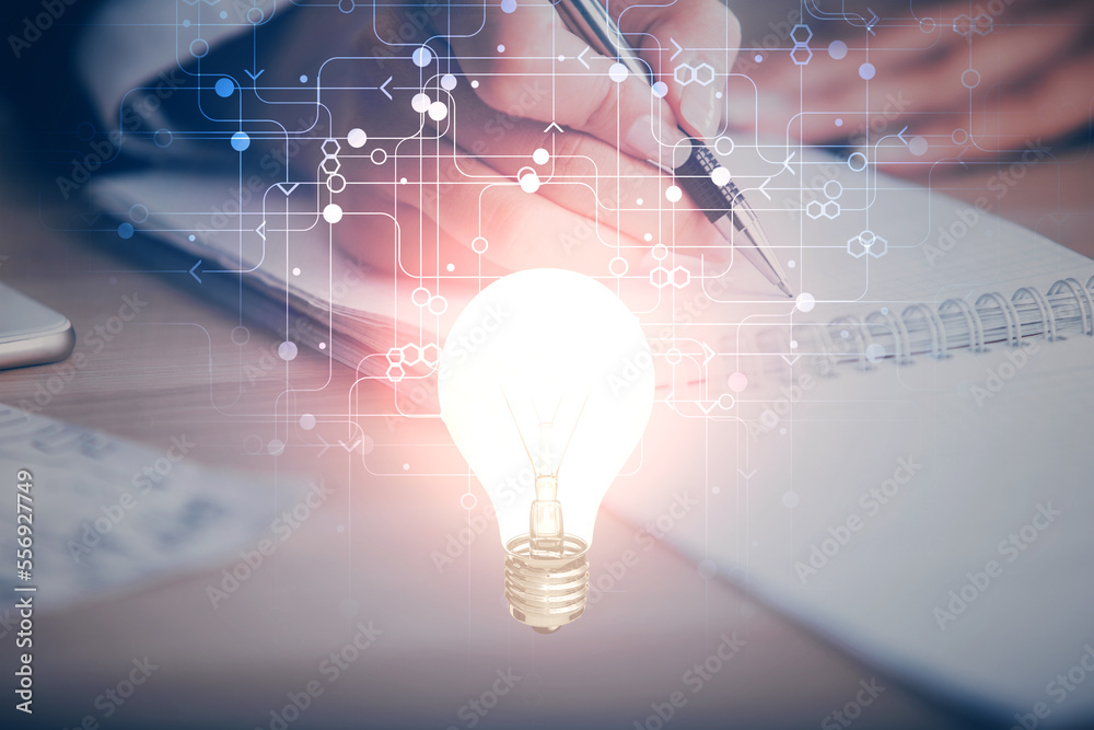 Poster bulb hologram over hands taking notes background. concept of idea. double exposure