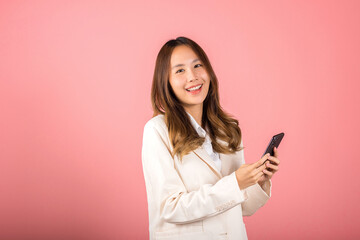 Female surprised and sms chatting internet online on smartphone studio shot isolated on pink...