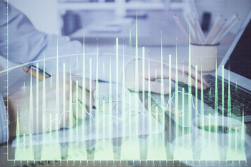 Multi exposure of stock market graph with man working on laptop on background. Concept of financial analysis.