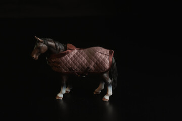 Black toy horse isolated on black background