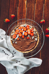 Chocolate tart decorated with strawberries and coconut flakes