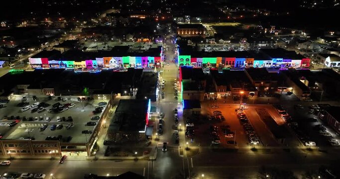 Rochester, Michigan skyline at night lit up with Christmas lights on buildings and drone video wide shot moving forward.