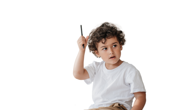 Thoughtful little curly caucasian boy sitting holding pencil looking aside against transparent background. Preschooler Spanish kid learning letters at home. Knowledge, home studying. Childhood concept