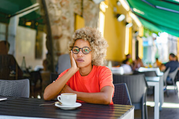 woman with cup drinking cafe at city street cafe terrace