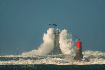 phare dans la tempête en Bretagne, survolé par un hélicoptère © jmbreizh
