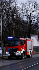 wóz strażacki stojący na poboczu jezdni gotowy do akcji
