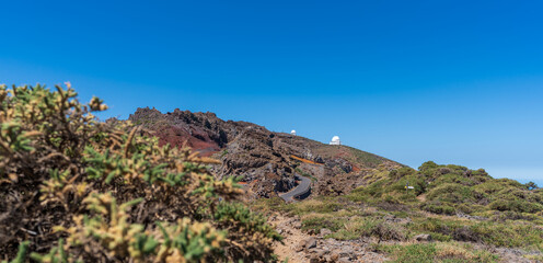 Mountain road and astronomical observatories under blue sky