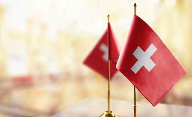 Small flags of the Switzerland on an abstract blurry background