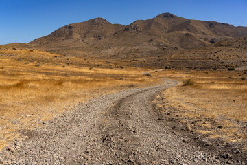 Panoramic view of of mountains with a dirt road in the Gata Cape Natural Park coast. Almería,...