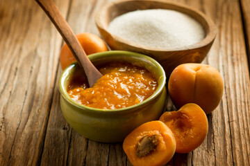 apricot jam with ingredients over wood background