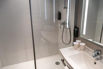 Minimalistic hotel bathroom with shower and paper cups on the sink, hotel bathroom mockup